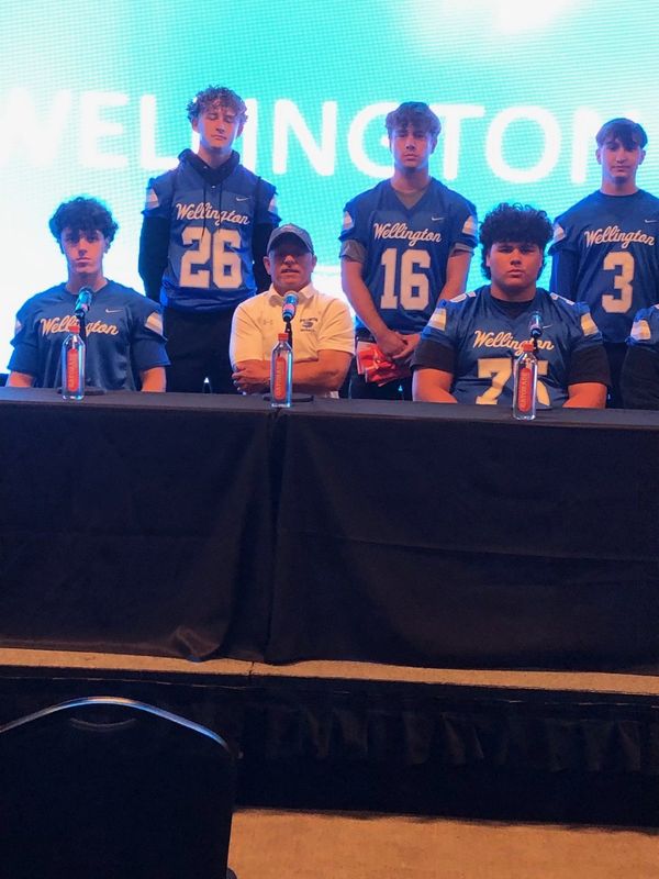 Wellington football head coach Pete Walker (third from left) is joined by Wolverines football players at Miami Dolphins Media Day on Saturday, Aug. 9 in Miami Gardens.