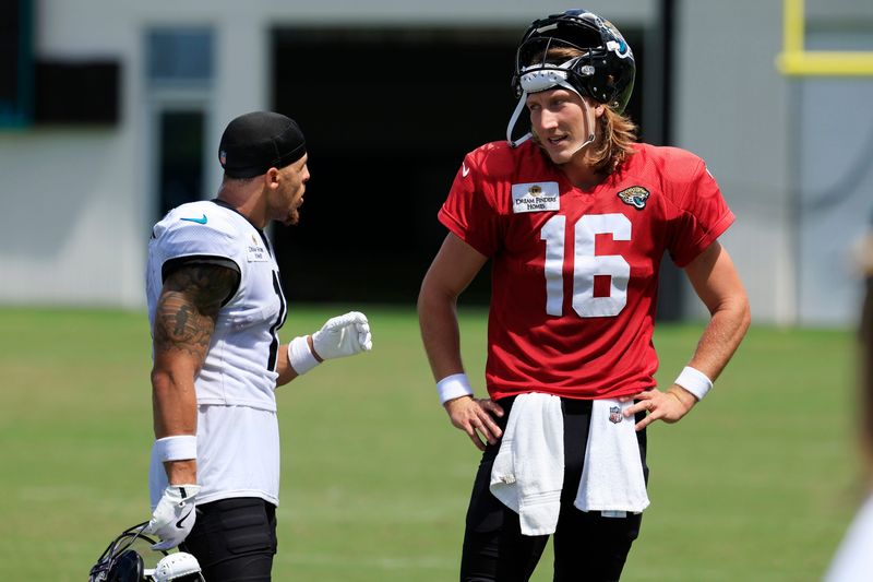 Jacksonville Jaguars wide receiver Parker Washington (11), left, and quarterback Trevor Lawrence (16) talk after an NFL training camp session at the Miller Electric Center, Thursday, Aug. 14, 2025 in Jacksonville, Fla.
