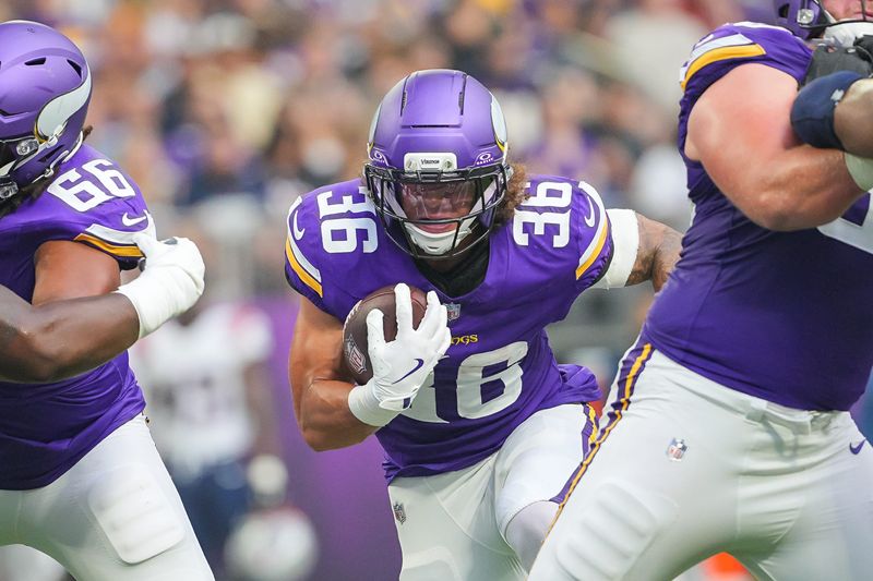 Aug 16, 2025; Minneapolis, Minnesota, USA; Minnesota Vikings running back Zavier Scott (36) runs with the ball against the New England Patriots in the second quarter at U.S. Bank Stadium. Mandatory Credit: Brad Rempel-Imagn Images