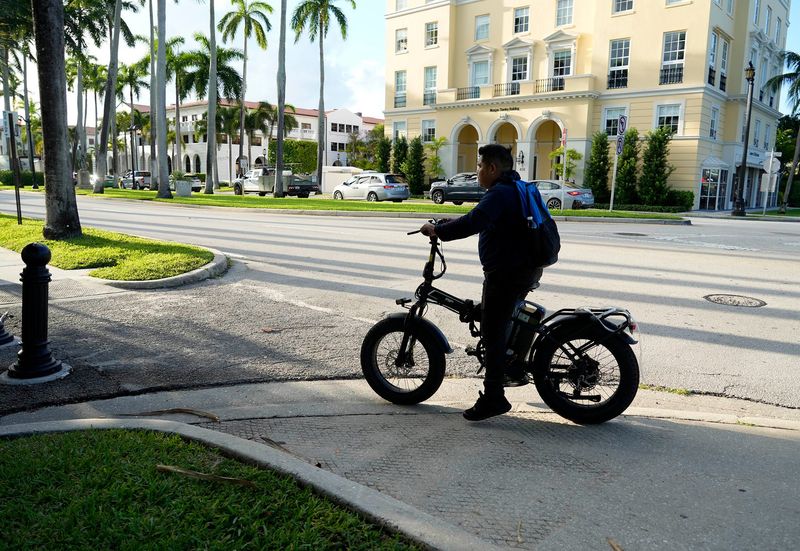 A person on an electric bike travels east on Palm Beach's Royal Palm Way in August 2025.