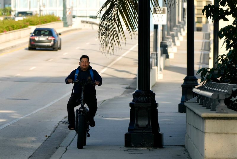 A person on an electric bike travels east on the Royal Palm Way on Aug. 18.