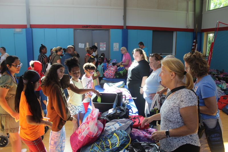 Children pick up backpacks filled with school supplies during Grace Place for Children and Families’ fourth annual Back to School Bash in Naples, Florida, on July 19, 2025.