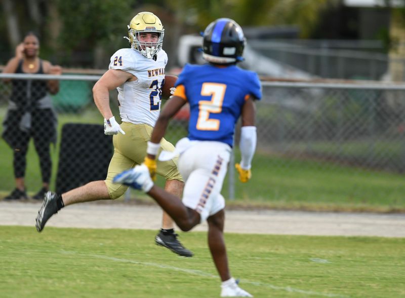 Cardinal Newman’s Phoenix Donghia , 24, sprints to the end zone past John Caroll’s Jacob Smith, 2, to score in the 2nd quarter.
