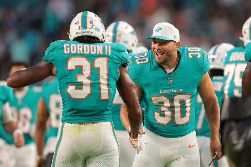 Aug 23, 2025; Miami Gardens, Florida, USA; Miami Dolphins fullback Alec Ingold (30) celebrates with running back Ollie Gordon II (31) against the Jacksonville Jaguars during the second quarter at Hard Rock Stadium. Mandatory Credit: Sam Navarro-Imagn Images