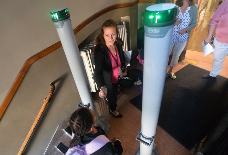 Edison Elementary School Principal Diane Sutton helps guide students through a metal detector on the first day of school in Erie on Aug. 28, 2023. Sutton later said there had been no major issues for the 419 students enrolled for the new school year.