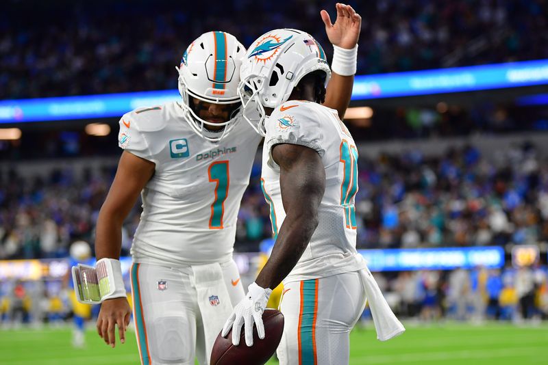 Dec 11, 2022; Inglewood, California, USA; Miami Dolphins wide receiver Tyreek Hill (10) celebrates his touchdown scored against the Los Angeles Chargers with quarterback Tua Tagovailoa (1) during the first half at SoFi Stadium. Mandatory Credit: Gary A. Vasquez-USA TODAY Sports