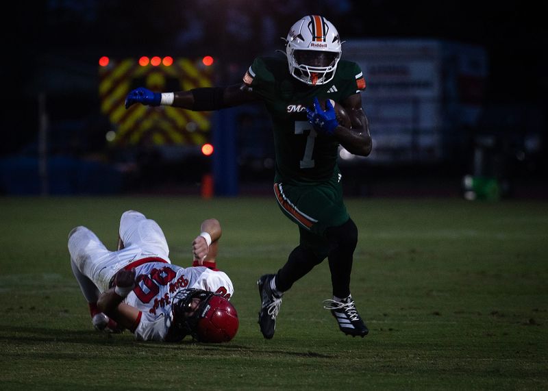 Mosley's Will Arboleda (7) eludes Bay's Aiden Jones (90) during their game at Tommy Oliver Stadium in Panama City, Fla., Aug. 29, 2025. (Tyler Orsburn/News Herald)