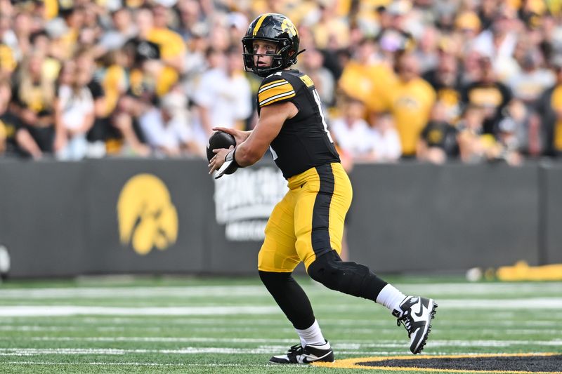 Aug 30, 2025; Iowa City, Iowa, USA; Iowa Hawkeyes quarterback Mark Gronowski (11) prepares to throw a pass against the Albany Great Danes during the first quarter at Kinnick Stadium. Mandatory Credit: Jeffrey Becker-Imagn Images