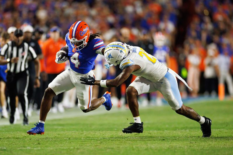 Aug 30, 2025; Gainesville, Florida, USA; Florida Gators wide receiver TJ Abrams (4) pushes off Long Island Sharks defensive back Chase Davis (27) during the second half at Ben Hill Griffin Stadium. Mandatory Credit: Matt Pendleton-Imagn Images