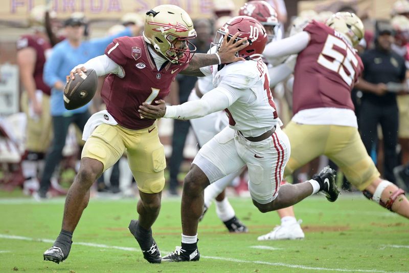 Aug 30, 2025; Tallahassee, Florida, USA; Florida State Seminoles quarterback Tommy Castellanos (1) stiff arms Alabama Crimson Tide linebacker Justin Jefferson (10) during the second half at Doak S. Campbell Stadium. Mandatory Credit: Melina Myers-Imagn Images