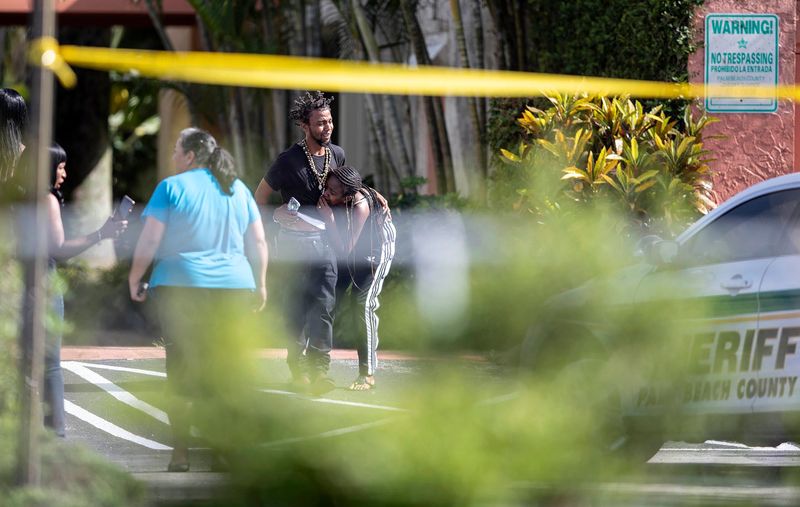 Onlookers are overcome by grief after one man was killed and another man was taken to the hospital in a shooting in Royal Palm Beach in July 2018. (ALLEN EYESTONE/PALM BEACH POST)