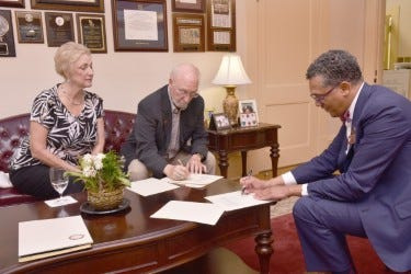 Bethune-Cookman University President Albert Mosley, right, and retired United Methodist Church administrator and Rev. Robert Gibbs, center, sign an agreement in which Gibbs contributed $200,000 to the school for a scholarship program aimed at supporting students interested in careers in the Christian ministry.