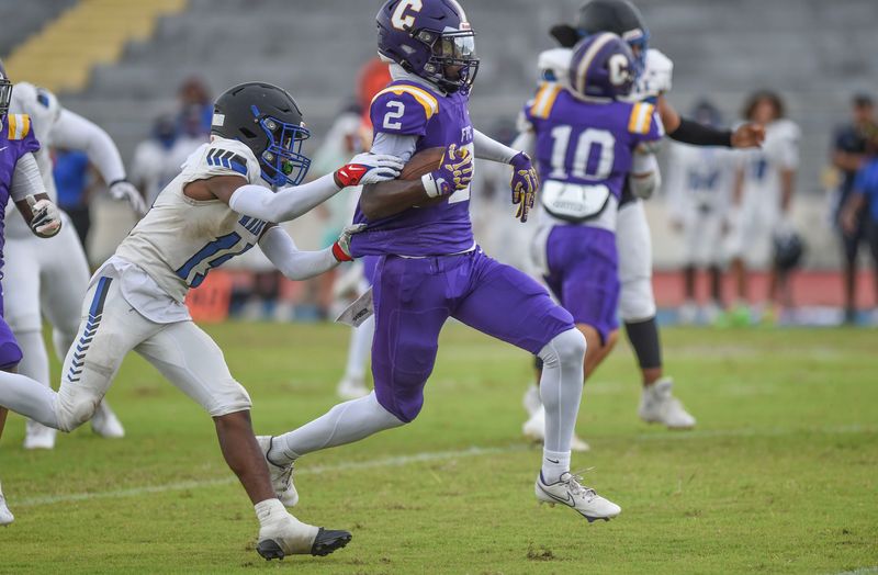 Jakoby Blackwood, 2, of Fort Pierce Central, runs to escape Elijah Josepn, 15, of Hollywood Hills during a first half play at Lawnwood Stadium on Sept. 4, 2025, in Fort Pierce.