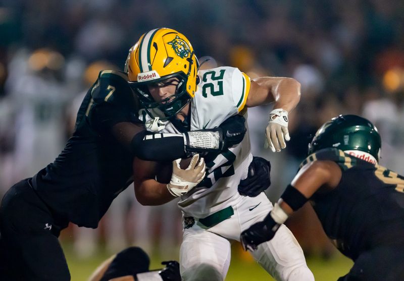 Forest Ethan Collins (22) gets grabbed by Trinity Catholic Micheal Neal (7) during second half of an FHSAA football game at Trinity Catholic in Ocala, FL on Friday, September 5, 2025. [Alan Youngblood/Ocala Star-Banner]