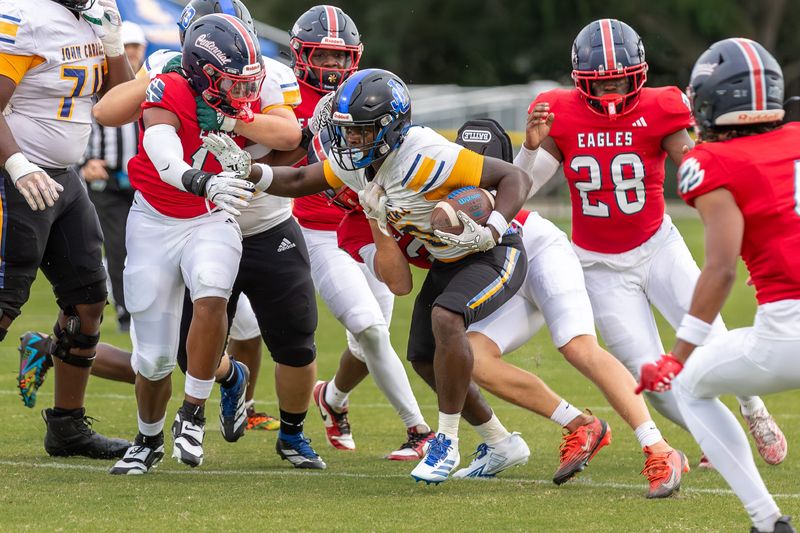 John Carroll Catholic’s Jeremy Pittman Jr. (0) attempts to avoid being tackled in a high school football game against St. Lucie West Centennial on Sept. 5, 2025, at South County Regional Sports Complex in Port St. Lucie. John Carroll won 35-6.