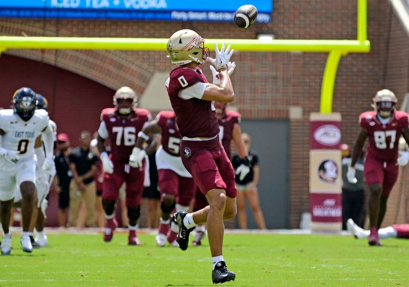 Sep 6, 2025; Tallahassee, Florida, USA; Florida State Seminoles wide receiver Duce Robinson (0) catches a touchdown during the first half against the East Texas A&M at Doak S. Campbell Stadium. Mandatory Credit: Melina Myers-Imagn Images