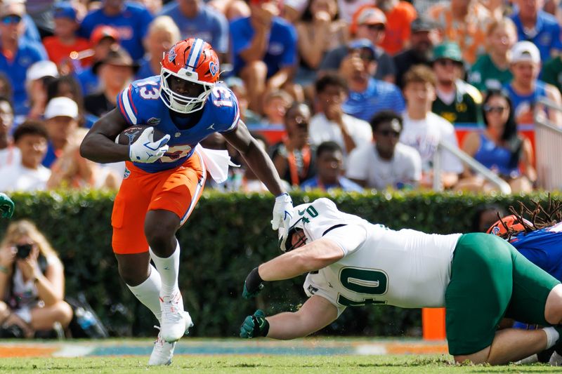 Sep 6, 2025; Gainesville, Florida, USA; Florida Gators running back Jadan Baugh (13) rushes past South Florida Bulls defensive tackle Jacob Merrifield (40) during the first half at Ben Hill Griffin Stadium. Mandatory Credit: Matt Pendleton-Imagn Images