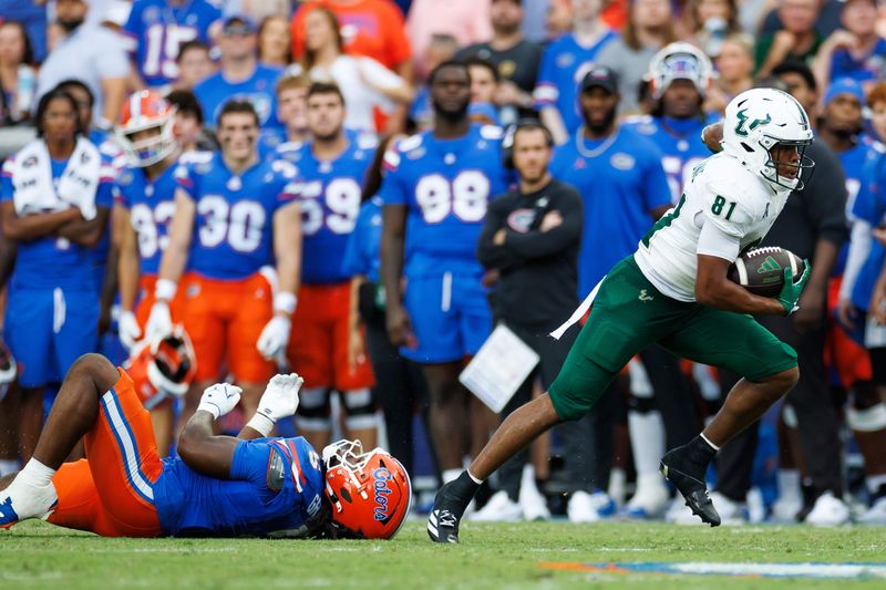 South Florida Bulls wide receiver Christian Neptune breaks free from a tackle attempt by Florida Gators linebacker Myles Graham.