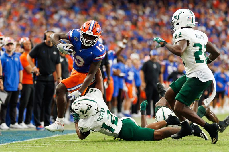 Sep 6, 2025; Gainesville, Florida, USA; Florida Gators running back Jadan Baugh (13) rushes with the ball past South Florida Bulls safety Jabari Smith (12) during the second half at Ben Hill Griffin Stadium. Mandatory Credit: Matt Pendleton-Imagn Images