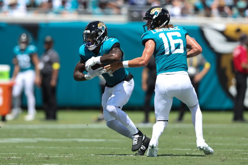 Sep 7, 2025; Jacksonville, Florida, USA; Jacksonville Jaguars quarterback Trevor Lawrence (16) hands off to running back Tank Bigsby (4) against the Carolina Panthers during the first half at EverBank Stadium. Mandatory Credit: Morgan Tencza-Imagn Images