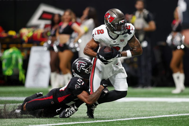 Sep 7, 2025; Atlanta, Georgia, USA; Tampa Bay Buccaneers wide receiver Emeka Egbuka (2) runs with the ball for a touchdown against Atlanta Falcons cornerback Mike Hughes (21) during the second quarter at Mercedes-Benz Stadium. Mandatory Credit: Brett Davis-Imagn Images