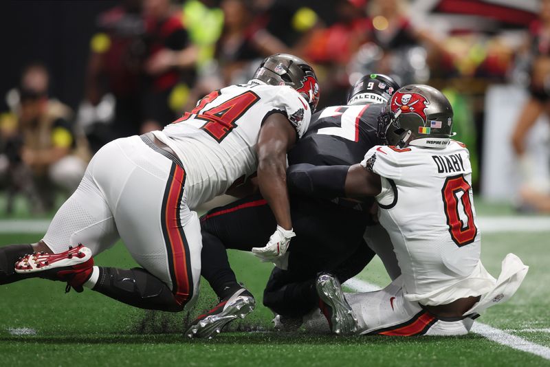 Sep 7, 2025; Atlanta, Georgia, USA; Tampa Bay Buccaneers linebacker Yaya Diaby (0) and defensive tackle Calijah Kancey (94) tackle Atlanta Falcons quarterback Michael Penix Jr. (9) during the second quarter at Mercedes-Benz Stadium. Mandatory Credit: Brett Davis-Imagn Images