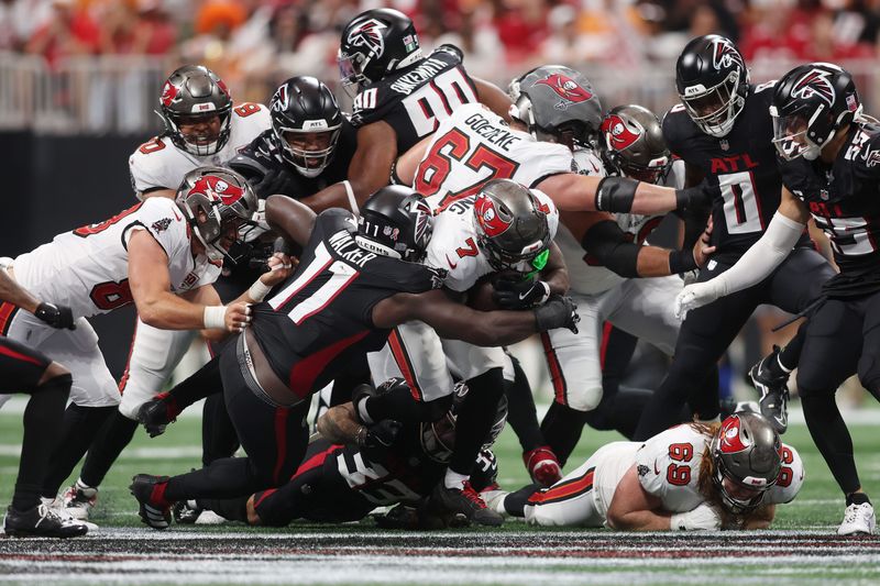Sep 7, 2025; Atlanta, Georgia, USA; Tampa Bay Buccaneers running back Bucky Irving (7) runs with the ballag Atlanta Falcons linebacker Jalon Walker (11) during the fourth quarter at Mercedes-Benz Stadium. Mandatory Credit: Brett Davis-Imagn Images