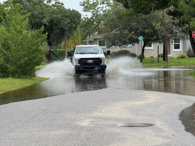 A truck sloshes through a flooded street in Davis Shores after a flooding event. A new state law allows police to ticket drivers who create damaging wakes on flooded streets.