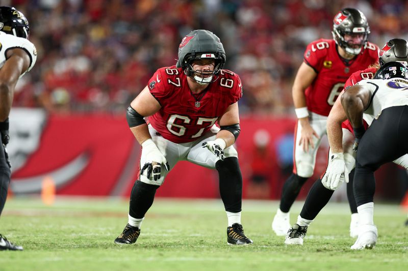 Oct 21, 2024; Tampa, Florida, USA; Tampa Bay Buccaneers offensive tackle Luke Goedeke (67) wears a guardian helmet as he lines up against the Baltimore Ravens in the fourth quarter at Raymond James Stadium. Mandatory Credit: Nathan Ray Seebeck-Imagn Images