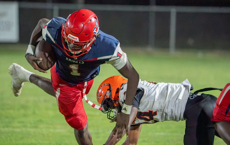 Vanguard Terrance Lewis (1) gets tripped up by Leesburg Kaleque Mosley (24) during a FHSAA football game at Booster Stafdium in Ocala, FL on Friday, September 12, 2025. [Alan Youngblood/Ocala Star-Banner]