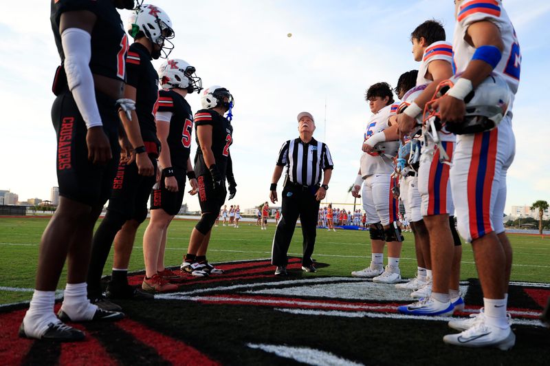Bishop Kenny, left, and Bolles players look on as the coin toss is performed before a 2025 game.