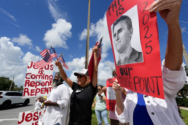 Community members gather at the intersection of State Road 60 and 58th Avenue in Indian River County just west of Vero Beach, for a Charlie Kirk flag wave gathering, Sept. 13, 2025, to honor the 31-year-old activist who was killed by a single gunshot while speaking in front of about 3,000 people as part of his ‘American Comeback Tour’ at Utah Valley University.