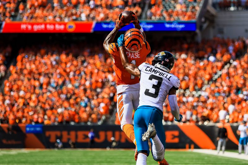 Sep 14, 2025; Cincinnati, Ohio, USA; Cincinnati Bengals wide receiver Ja'Marr Chase (1) catches a pass against Jacksonville Jaguars cornerback Tyson Campbell (3) in the second half at Paycor Stadium. Mandatory Credit: Katie Stratman-Imagn Images