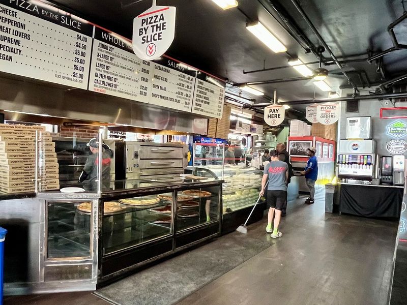 Work your way down the long counter, ordering slices, subs, salads and more at Downtown House of Pizza (DHOP) in Fort Myers.