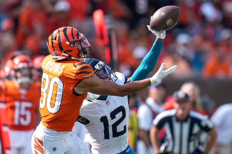 Jacksonville Jaguars defensive back Travis Hunter (12) breaks up a pass intended for Cincinnati Bengals wide receiver Andrei Iosivas (80) before a pass interference penalty is called in the fourth quarter of the NFL Week 2 game between the Cincinnati Bengals and the Jacksonville Jaguars at Paycor Stadium in downtown Cincinnati on Sunday, Sept. 14, 2025. The Bengals came back from a halftime deficit to win 31-27.