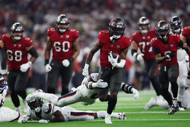 Sep 15, 2025; Houston, Texas, USA; Tampa Bay Buccaneers running back Rachaad White (1) rushes and breaks a tackle from Houston Texans linebacker Azeez Al-Shaair (0) during the third quarterat NRG Stadium. Mandatory Credit: Troy Taormina-Imagn Images