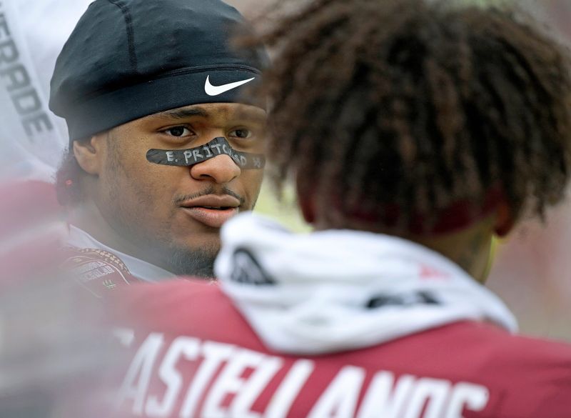 Florida State Seminoles safety Earl Little Jr. talks with quarterback Tommy Castellanos.