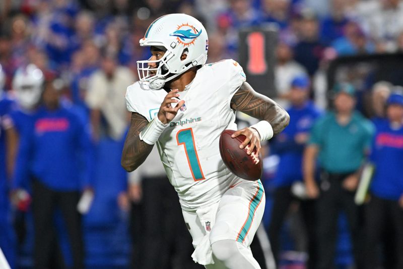 Sep 18, 2025; Orchard Park, New York, USA; Miami Dolphins quarterback Tua Tagovailoa (1) runs the ball against the Buffalo Bills in the second quarter at Highmark Stadium. Mandatory Credit: Mark Konezny-Imagn Images