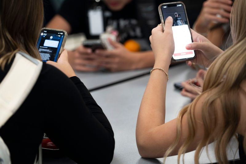 Students use their phones during lunch time at Roosevelt High School on Thursday, Sept. 18, 2025, in Des Moines.