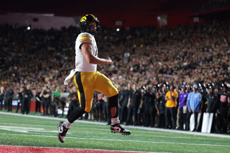 Sep 19, 2025; Piscataway, New Jersey, USA; Iowa Hawkeyes quarterback Mark Gronowski (11) scores a rushing touchdown during the first half against the Rutgers Scarlet Knights at SHI Stadium. Mandatory Credit: Vincent Carchietta-Imagn Images
