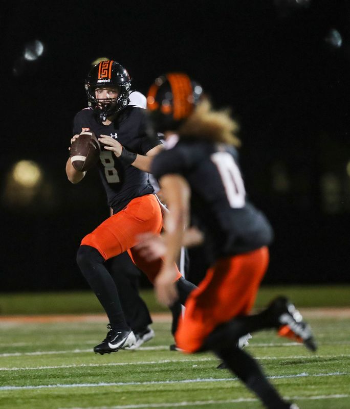 Lely Trojans quarterback Brady Quinn (8) looks to pass to receiver Ty Collins (0) during the second quarter of a Week 5 game against the Sarasota Booker Tornadoes at Lely High School in Naples, Fla., on Friday, Sept. 19, 2025.