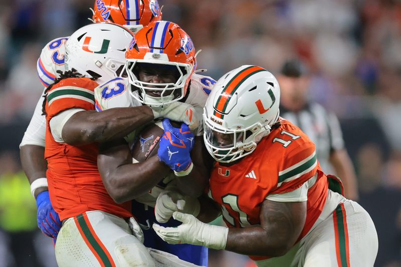 Florida Gators running back Jadan Baugh (13) carries the football against Miami Hurricanes defensive lineman David Blay Jr. (11) during the third quarter at Hard Rock Stadium.