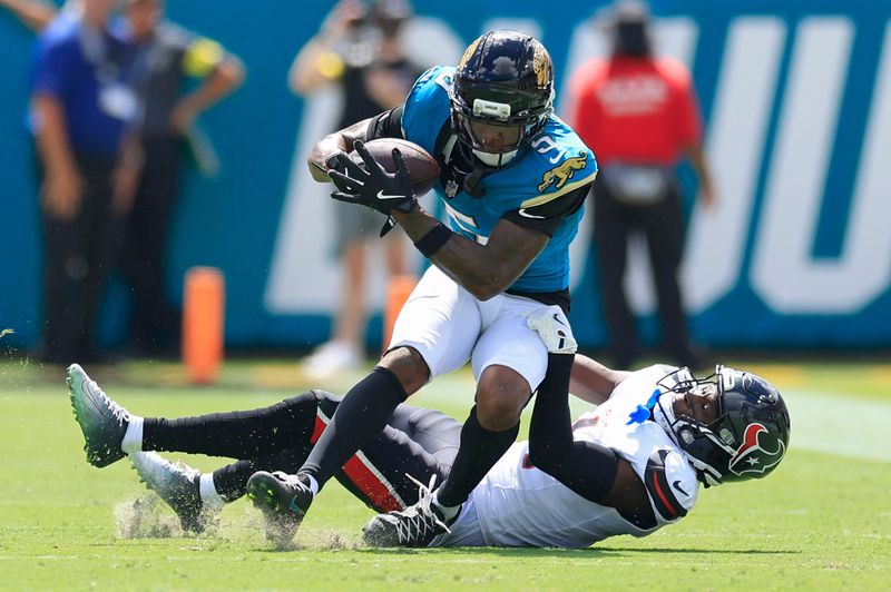 Jacksonville Jaguars wide receiver Dyami Brown (5) is tackled by Houston Texans cornerback Kamari Lassiter (4) during the first quarter of an NFL football matchup at EverBank Stadium, Sunday, Sept. 21, 2025, in Jacksonville, Fla. The Jaguars defeated the Texans 17-10. The Jaguars defeated the Texans 17-10.