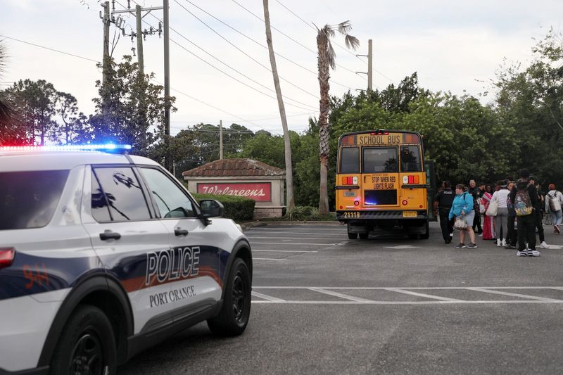 Port Orange police watch over a school bus in the parking lot of a Walgreen's at Taylor Road and Williamson Boulevard in Port Orange on Tuesday, Sept. 23, 2025. The bus, which carried students from Spruce Creek High School, was searched following a bomb threat which turned out to be unsubstantiated, according to Volusia County Schools.