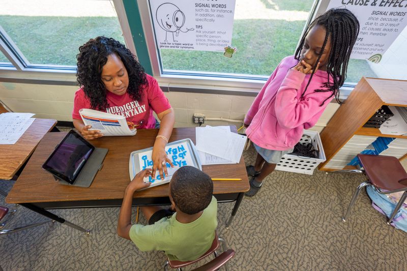 Shunteen Cineus, a reading teacher at Ruediger Elementary School, works one-on-one with a student as another another waits to assistance Wednesday, Sept. 17, 2025.