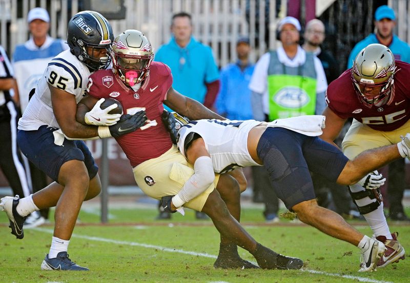 Nov 23, 2024; Tallahassee, Florida, USA; Florida State Seminoles running back Kam Davis (3) is tackled during the second half of the game against the Charleston Southern Buccaneers at Doak S. Campbell Stadium. Mandatory Credit: Melina Myers-Imagn Images
