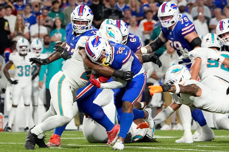 Sep 18, 2025; Orchard Park, New York, USA; Miami Dolphins linebacker Jordyn Brooks (20) tackles Buffalo Bills running back Ty Johnson (26) in the fourth quarter at Highmark Stadium. Mandatory Credit: Gregory Fisher-Imagn Images