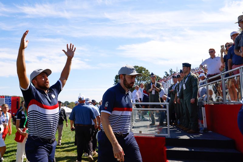 Sep 26, 2025; Bethpage, New York, USA; Team USA golfers Xander Schauffele and Patrick Cantlay celebrate as they walk off the 18th green on the first day of competition for the Ryder Cup at Bethpage Black. Mandatory Credit: Peter Casey-Imagn Images