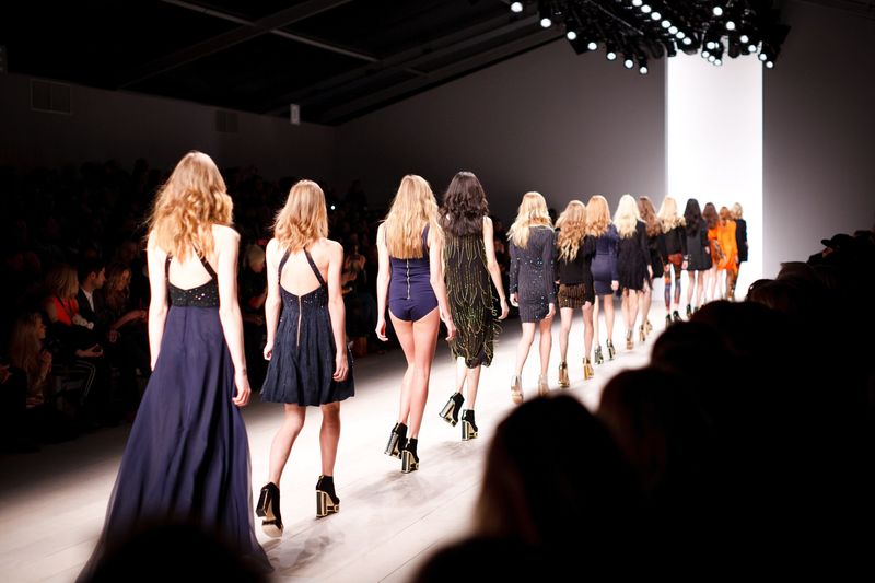Models walking down catwalk.