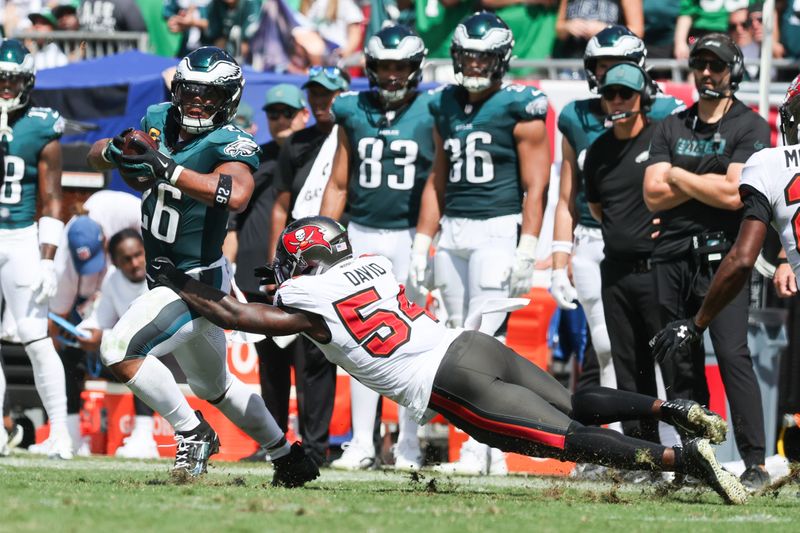 Sep 28, 2025; Tampa, Florida, USA; Philadelphia Eagles running back Saquon Barkley (26) is tackled byTampa Bay Buccaneers outside linebacker Lavonte David (54) during the second quarter at Raymond James Stadium. Mandatory Credit: Kim Klement Neitzel-Imagn Images